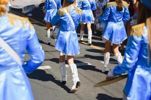 majorettes com branco e azul uniformes executar dentro a ruas do a cidade. fotográfico Series foto