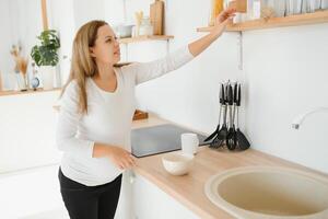 grávida mulher dentro cozinha fazer salada foto