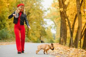 mulher com cachorro passeando no parque foto