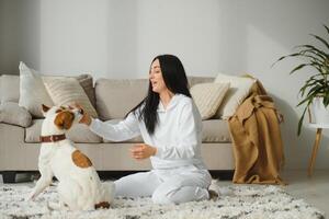 lindo jovem menina jogando com uma agradável fofa cachorro. foto