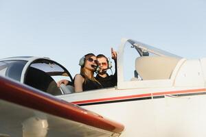 jovem mulher e piloto dentro dentro a cockpit do uma avião. frente Visão foto