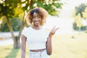 uma jovem fêmea afro-americano mulher desfrutando uma dia às a parque foto