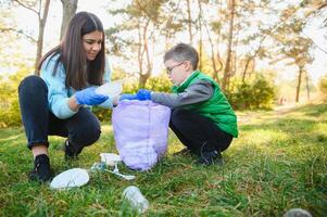 mãe ensina dela filho para limpar \ limpo acima Lixo dentro natureza. uma mulher remove plástico garrafas dentro uma bolsa. a tema do de Meio Ambiente poluição de lixo. foto