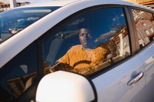 africano americano dirigindo a elétrico carro. foto