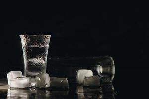 vodka dentro tiro óculos em Sombrio fundo foto
