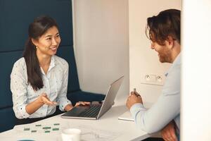 sorridente financeiro analista consultar cliente para aumentar o negócio lucratividade sentado dentro coworking foto