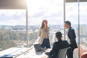 equipe do jovem empresários comunicando juntos dentro moderno escritório com panorâmico janelas foto