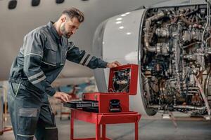 masculino CIA aérea mecânico trabalhando dentro aeronave hangar foto