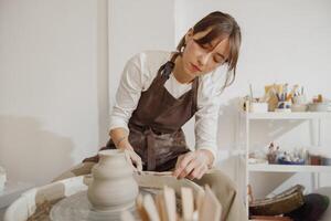 profissional fêmea artesão modelar argila tigela dentro cerâmica estúdio. cerâmica arte conceito foto
