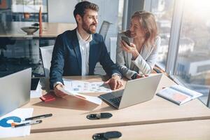 sorridente empresários às trabalhos conversa telefone e discutindo seus o negócio foto