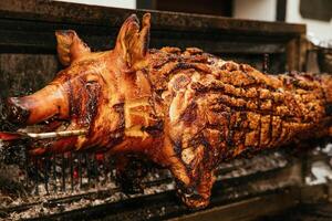 fechar-se do uma assado todo porco em uma cuspir às uma churrasco foto