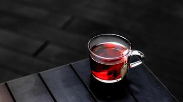 quente Rosa Mosqueta chá ou rosa quadril com chá saco servido dentro uma copo isolado em Sombrio fundo lado Visão foto