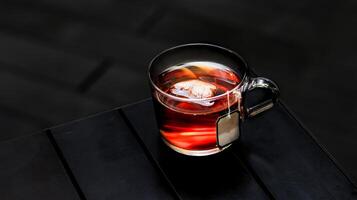 quente conde cinzento chá com chá saco servido dentro uma copo isolado em Sombrio fundo lado Visão foto