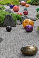 colorida vidro esferas espalhados em uma zen do jardim ajuntado cascalho, criando uma contraste entre natural tranquilidade e vibrante arte às kew jardins, Londres. foto