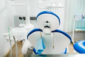 uma cadeira vazia no consultório do dentista. consultório de dentista vazio foto