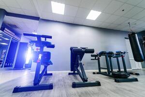 moderno equipamento para fazendo esporte exercícios dentro a luz academia. ginástica e Academia exercite-se Itens dentro Esportes clube foto