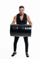 bonito homem com barril em isolado branco fundo. jovem fisiculturista exercite-se com barril. foto