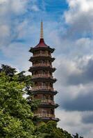 tradicional multicamadas pagode torre contra uma azul céu com nuvens às kew jardins, Londres. foto