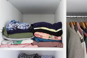 organizando roupas dentro uma armário de roupa em prateleiras para conforto e facilidade do Acesso foto