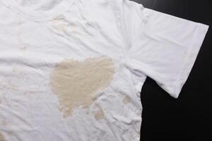 derramado café em uma branco camisa foto