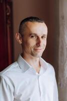 retrato do sorridente bem sucedido caucasiano homem dentro formal terno, posando dentro sala, feliz jovem masculino patrão ou CEO olhando às Câmera, mostrando confiança e força, Liderança conceito foto