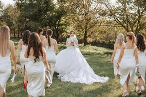 Casamento fotografia. uma morena noiva dentro uma branco vestir com uma ramalhete e dela morena amigas foto