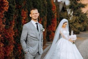 Casamento casal em uma andar dentro a outono parque. a noiva dentro uma lindo branco vestir. amor e relação conceito. noivo e noiva dentro natureza ao ar livre foto