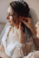 damas de honra alegrar dentro a manhã, ajudando para apertar a botões em a Casamento vestir e preparar para a Casamento cerimônia. elas levar fotos, sorriso, Socorro a noiva com dela sapato. foto