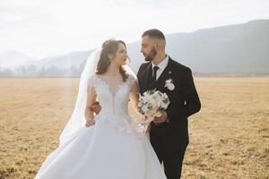 Casamento casal em uma andar dentro a outono parque. a noiva dentro uma lindo branco vestir. amor e relação conceito. noivo e noiva dentro natureza ao ar livre foto