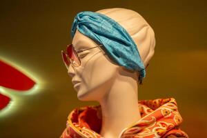 a face do uma fêmea manequim dentro oculos de sol atrás a vidro do uma exibição caso. foto