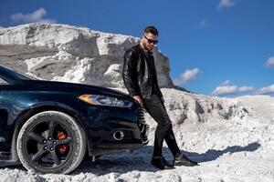 à moda bonito homem posando com carro. elegante jovem homem de negocios. foto