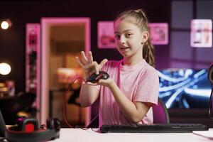 feliz jovem menina dentro estúdio revendo jogos rato dentro frente do Câmera dentro pessoal estúdio. alegre criança filmando eletrônicos transporte, apresentando com fio computador periférico para espectadores foto