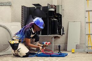 qualificado engenheiro encomendado de casa proprietário, preparando para anual ar condicionador manutenção. competente mecânico desembalar kit de ferramentas com profissional equipamento necessário para consertar defeituoso drenando linhas foto