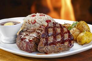 grelhado bife com batatas, arroz e churrasco molho foto