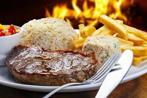 grelhado bife com batatas, arroz farofa foto