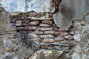 a velho tijolo parede este é poroso e corroendo até a tijolos estão visível Porque a cimento é descamação fora foto