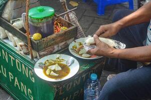 a processo do servindo uma típica sidoarjo Comida chamado Lontong kupang foto