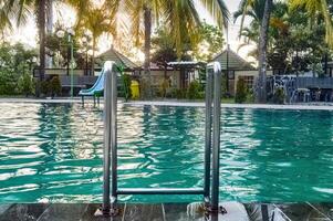 uma inoxidável aço natação escada dentro uma natação piscina com turquesa água foto
