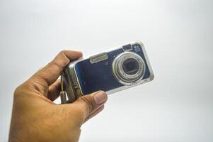 mão segurando a velho escola bolso Câmera isolado em branco fundo foto