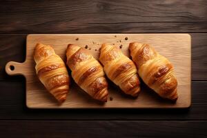 ai gerado recentemente cozido croissants em uma de madeira quadro, topo Visão foto