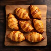 ai gerado croissants em uma corte borda em uma de madeira fundo, topo Visão foto