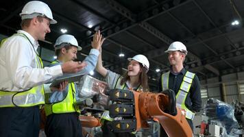 grupo do engenheiros e técnicos trabalhando juntos dentro uma robótico braço fábrica. inspecionando robô braço antes entregando para clientes foto