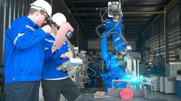 industrial trabalhadores trabalhando com robótico braço Soldagem máquina dentro fábrica, robótico braço Soldagem indústria e Engenharia conceito. foto