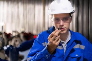 engenheiros e técnicos trabalhando juntos dentro uma robótico braço fábrica. Verifica a eletrônico poupar partes e elétrico sistema do a robótico braço. foto