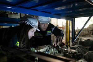 uma jovem fêmea engenheiro e uma masculino Supervisor trabalhos juntos dentro robótico braço poupar partes armazém, robótico braço indústria e Engenharia conceito. foto
