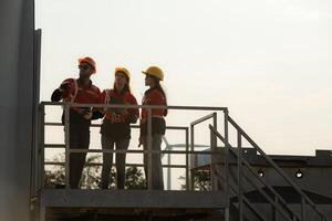 uma grupo do engenheiros e arquitetos trabalhos dentro chão do base terra do uma vento turbina foto