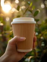 ai gerado uma fechar acima do uma mulher mão aperto uma quente café copo fez a partir de reciclável papel, banhado dentro a □ Gentil calor do cedo manhã luz solar foto