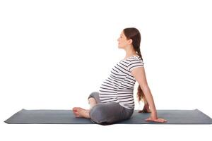 grávida mulher fazendo ioga asana baddha konasana foto