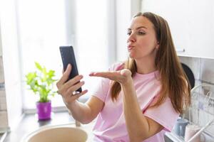 mulher sopro beijo às Smartphone para vídeo ligar foto
