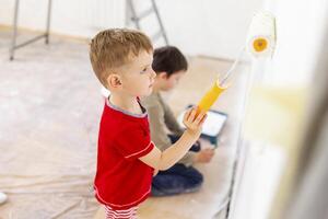 crianças pintura uma parede com escova e rolo dentro branco cor. crianças pintura parede foto